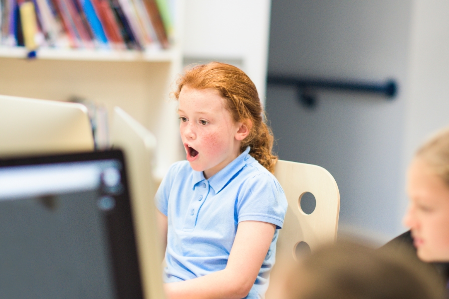 little girl on comouter looking surprised